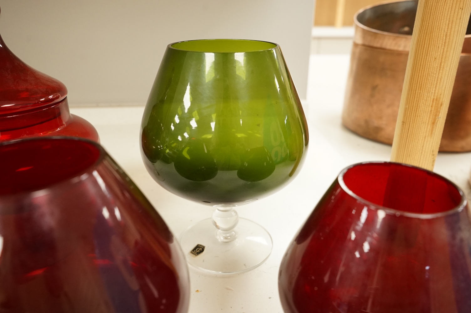 Five pieces of glassware to include a Swedish oversized brandy balloon, red glass sweetmeat dish and cover and a vase, largest 28cm high